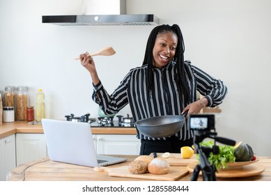 Happy African American Woman Vlogger Broadcasting Live Video Online Teaching Cooking Food In Kitchen At Home