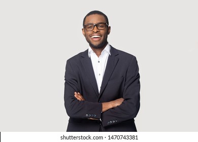 Happy African American Young Businessman In Formal Suit Wearing Eyeglasses Portrait. Smiling Millennial Confident Black Guy Posing For Photo, Looking At Camera, Isolated On Grey Studio Background.