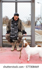 Happy African American Young Man Playing With Dog Outdoors In Autumn