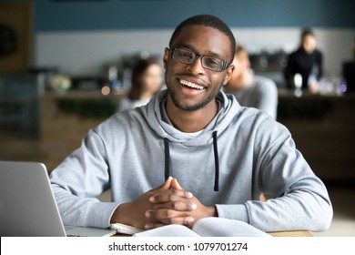 Happy African Casual Man In Glasses Sits At Cafe Table Looking At Camera, Cheerful Black Student Posing Studying With Book In Coffee House, Smiling Businessman Works On Laptop In Cafeteria, Portrait