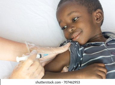 Happy African Child Gets A Needle Injection From A White Volunteer Doctor