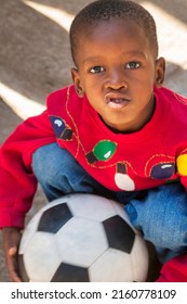 Happy African Child Playing With A Ball And Pulling Funny Faces