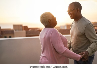 Happy african couple dancing outdoors at sunset - Soft focus on man face - Powered by Shutterstock