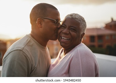 Happy african couple having tender moment outdoors at summer sunset - Focus on woman face