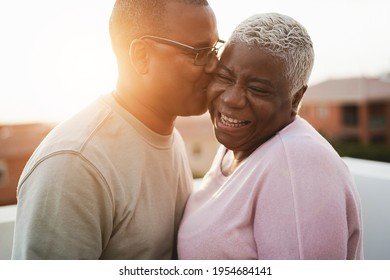 Happy african couple having tender moment outdoors at summer sunset - Focus on woman face - Powered by Shutterstock