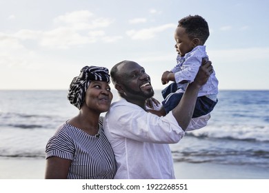 Happy African Couple With Little Child Outdoor On The Beach - Black Family Enjoy Playful Time Together 