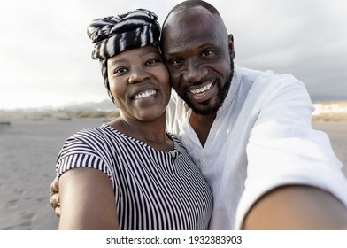 Happy African Couple Taking Selfie On The Beach With Mobile Smartphone Camera During Summer Vacation - Love Relationship Concept 