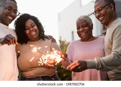 Happy African family celebrating with sparklers fireworks at house party - Parents unity and holidays concept - Powered by Shutterstock