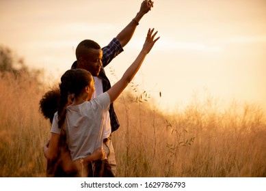 Happy African Family Enjoy Together On Meadow With Sunlight At Nature Park , Travel  Summer Holiday Lifestyle Healthy Concept   