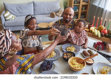 Happy African family of four toasting with drinks during holiday dinner at home - Shutterstock ID 2198533333