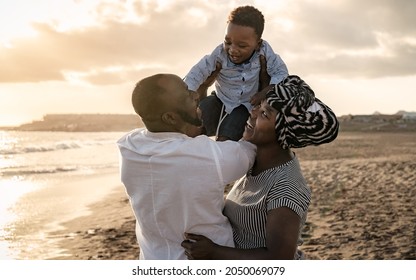 Happy African Family Having Fun On The Beach During Summer Holidays - Parents Love Concept