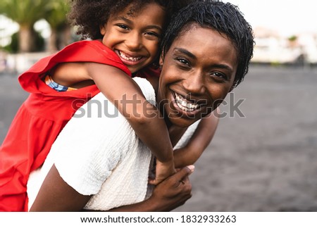 Happy African family having fun on the beach during summer holidays - Afro mother and daughter enjoying vacation days - Parents love and travel lifestyle concept