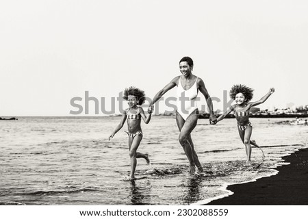 Happy African family having fun on the beach during summer vacations - Lovely family lifestyle concept