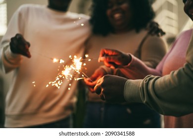 Happy african family using sparklers outdoor at home - Focus on right hand - Powered by Shutterstock