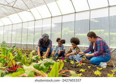 Happy African farmer family on agriculture farm growing organic vegetable together in greenhouse garden. Parents and little child kid working nature and gardening healthy food for sustainable living. - Powered by Shutterstock