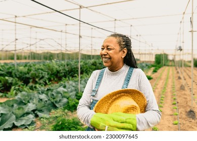 Happy African farmer working inside agricultural greenhouse - Farm people lifestyle concept - Powered by Shutterstock