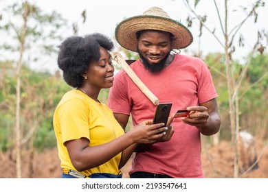 happy african farmers using a phone and credit card - Powered by Shutterstock