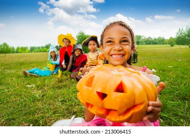 Happy African girl holds Halloween pumpkin 