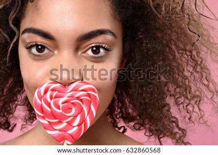 Happy african girl posing with sweetmeat