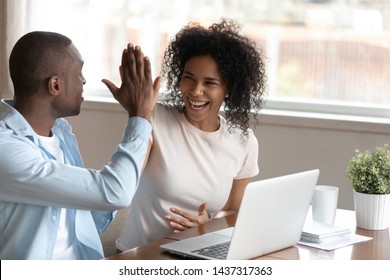 Happy african husband biracial wife couple sit at table near computer make fists yes gesture celebrating victory feels overjoyed unbelievable luck online lottery win betting, mortgage approval concept - Powered by Shutterstock