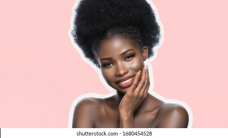 Happy African Lady Laughs Touching Face With Hand, Smiling Dark Skinned Model With Natural Make Up Isolated On Light Pink Back, Front View, In Skin Care Concept