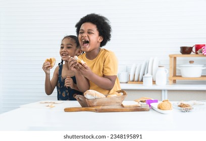 Happy African little children, brother and sister holding and showing heart shaped bread while having breakfast in kitchen. Child boy have fun playing with cute girl at home. Creative kids - Powered by Shutterstock