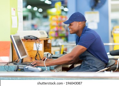 Happy African Male Cashier Working At Till Point In Supermarket