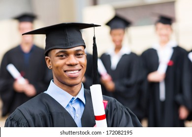 Happy African Male University Graduate With Classmates