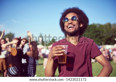 Happy African man drinking beer in festival 