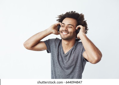 Happy African Man Smiling Listening To Music In Headphones. White Background.