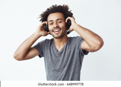 Happy African Man Smiling Listening To Music In Headphones. White Background.