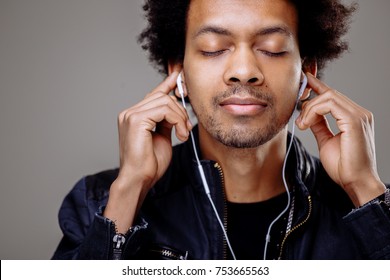 Happy african man smiling listening to music in headphones. White background. - Powered by Shutterstock