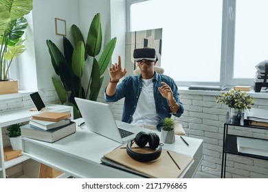 Happy African Man Wearing Virtual Reality Glasses While Sitting At Working Place