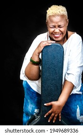 Happy African Mature Woman Posing In Studio With A Guitar