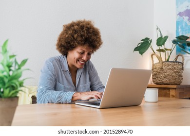 Happy African Mature Woman Using Laptop Computer At Home Office - Focus In Face