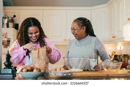 Happy African mother and daughter preparing a homemade dessert - Powered by Shutterstock