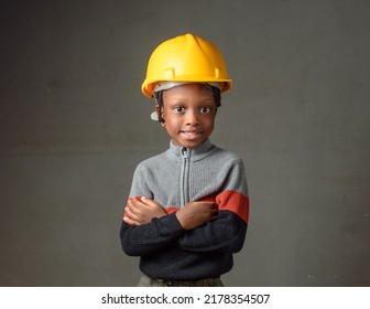 A Happy African Nigerian Girl Child With Yellow Safety Helmet Modeling As A Professional Construction Or Civil Engineer, Architect And Builder Among Others