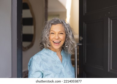 Happy african senior caucasian women opening door and welcoming somebody. Spending time together at home. - Powered by Shutterstock