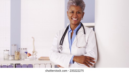 Happy African Senior Doctor Standing In Office 