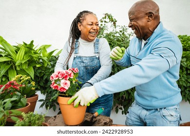 Happy African senior people gardening together outdoor - Powered by Shutterstock