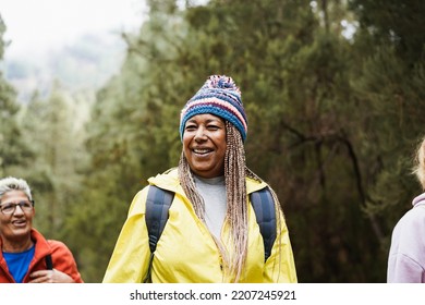 Happy african senior woman having fun during trekking day in to the wood - Focus on face - Powered by Shutterstock