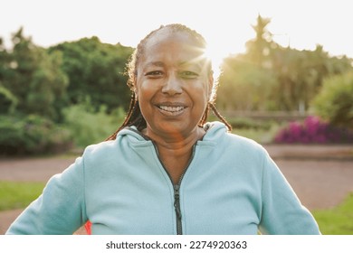 Happy african senior woman smiling on camera after sport workout at city park - Joyful elderly and healthy lifestyle concept - Powered by Shutterstock