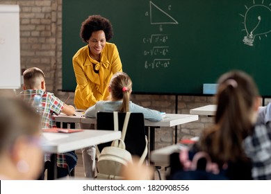 Happy African teacher communicating with her students during a class in the classroom.  - Shutterstock ID 1820908556