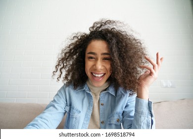 Happy african teen girl blogger talking to camera video calling, recording vlog. Happy afro young woman laughing distance chatting at home office. Funny social media influencer streaming. Webcam view