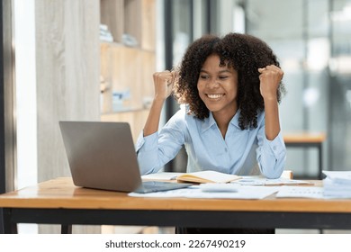 happy African woman Businesswoman, manager, or freelancer working remotely from home, enjoying self-employment growth, or getting a good deal on the desk with a laptop and data visualization.