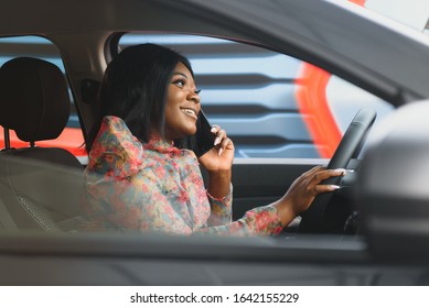 Happy African Woman Driving A New Car