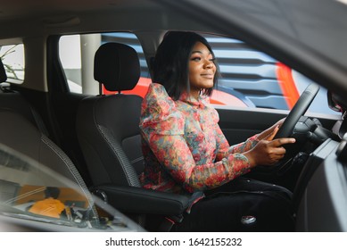 Happy African Woman Driving A New Car