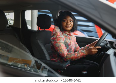 Happy African Woman Driving A New Car