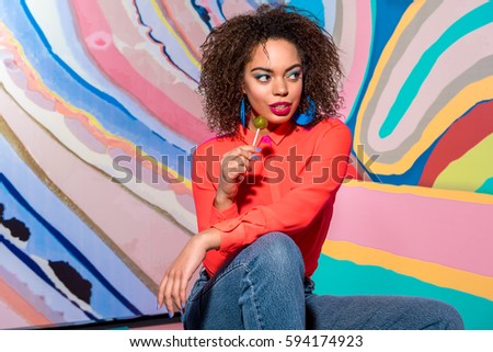 Happy african woman eating candy
