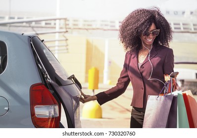 Happy African Woman With Shopping Bags Opening Car